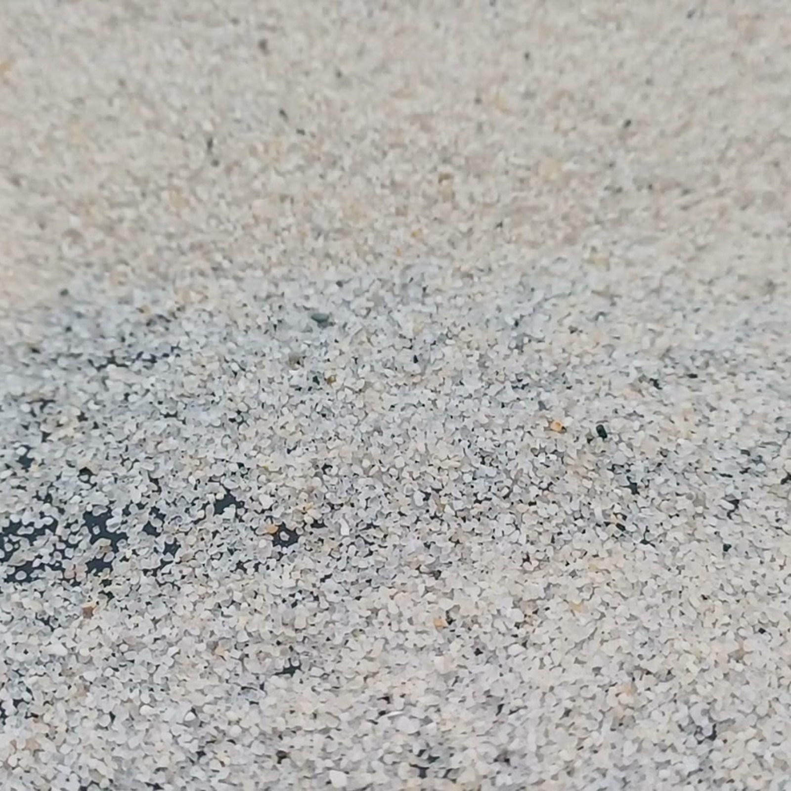 Aquariumsand Naturweiß, 0,2–0,5 mm, 25 kg: Helle Körner auf dunklem Untergrund.