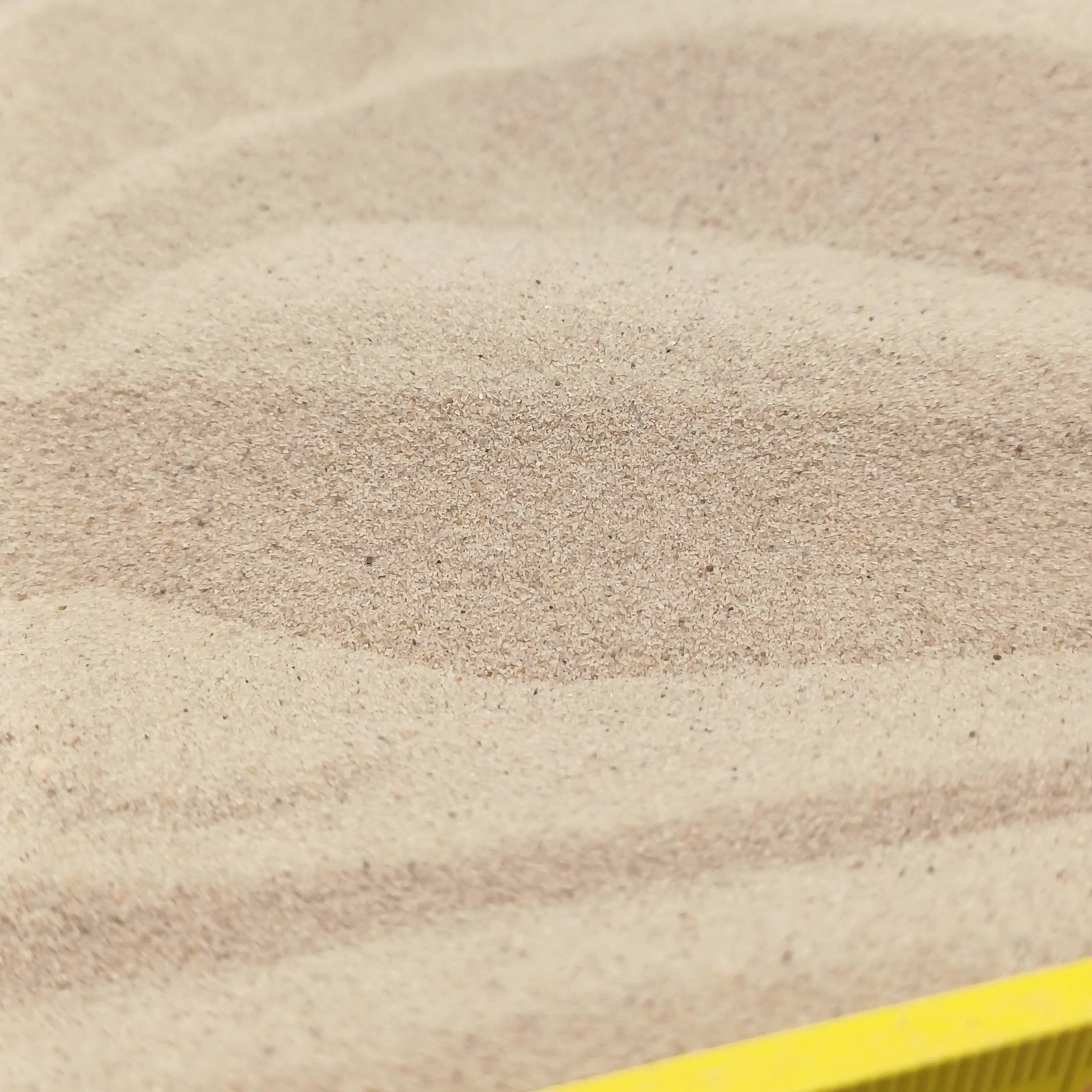 Aquariumsand Naturbeige, 0,1–0,4 mm, 25 kg: Sandwellen hinter dem Maßstab.