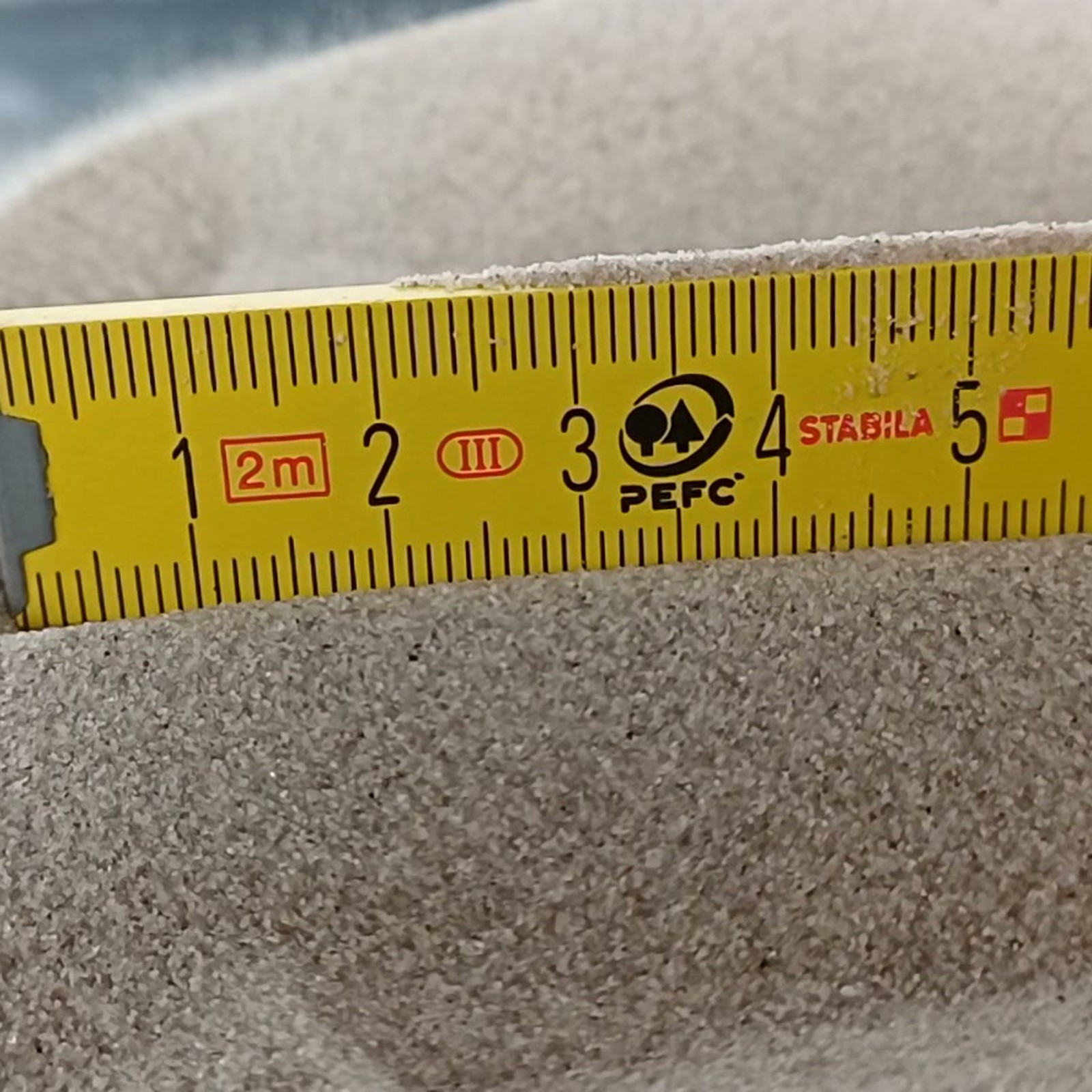 Vogelsand Naturgrau, 0,1–0,4 mm, 25 kg: Körnung am Gliedermaßstab.