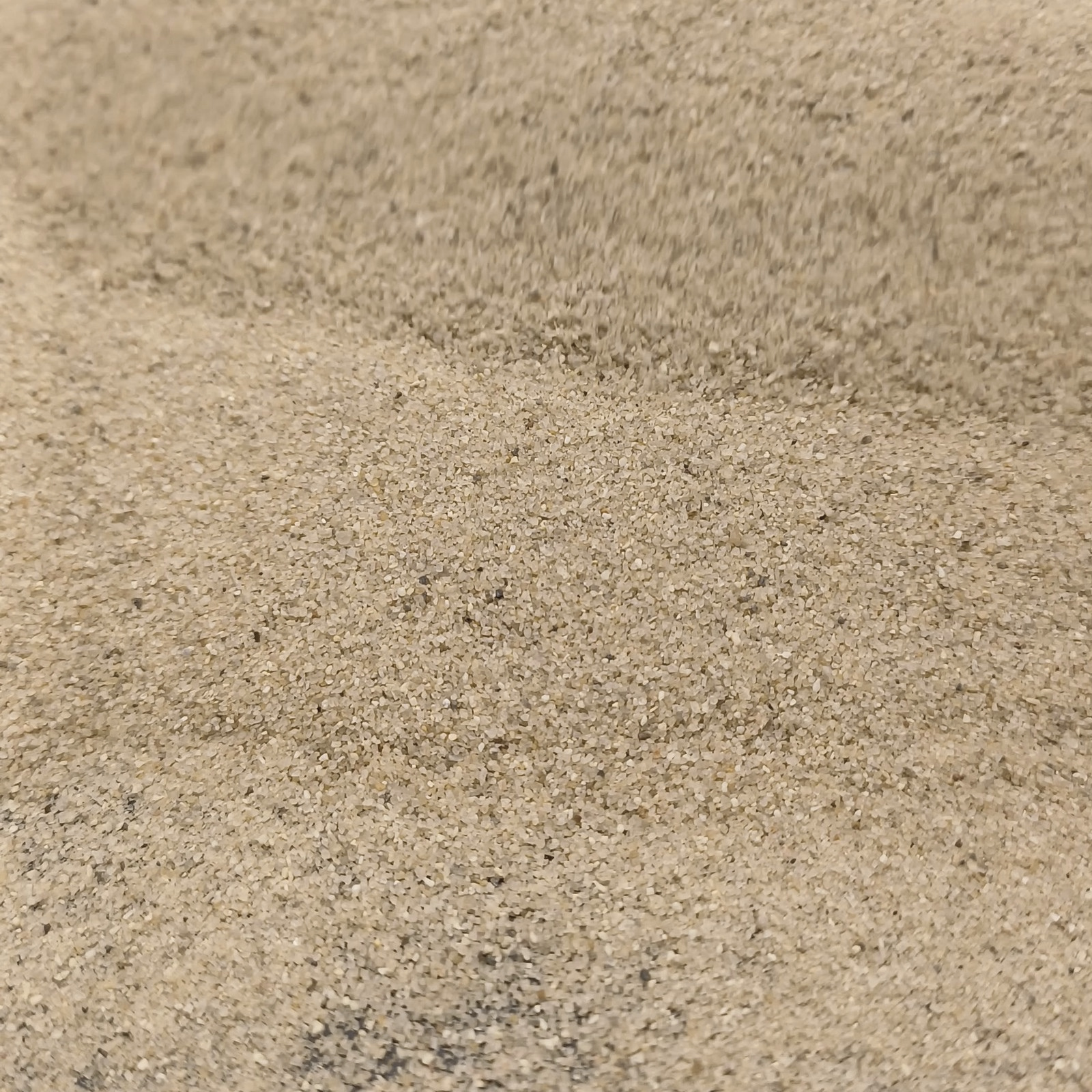 Aquariumsand Naturbeige, 0,1–0,5 mm, 6,3 kg: Nahaufnahme einer flachen beigen Mulde.