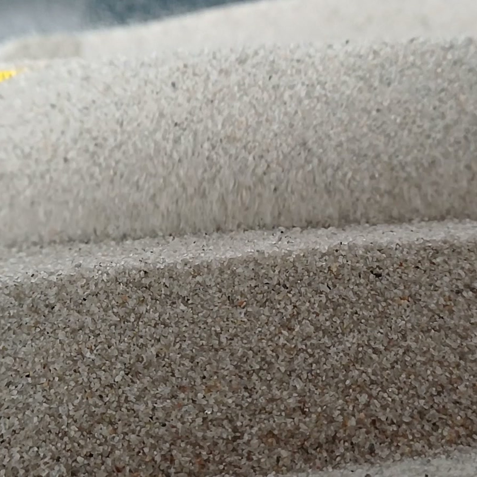 Aquariumsand Naturgrau, 0,1–0,5 mm, 10 kg: Vordere und hintere Sandkante mit Rinne dazwischen.
