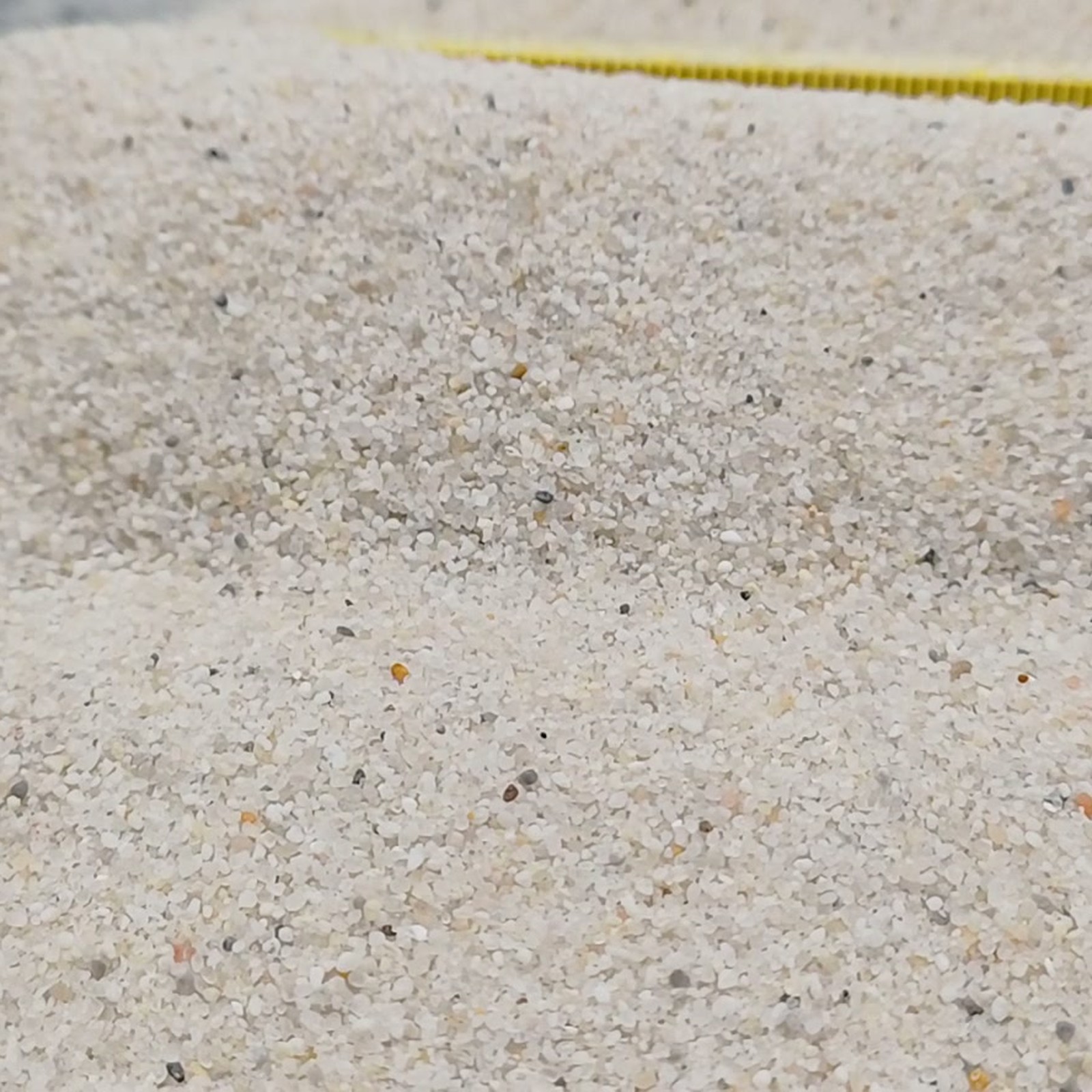 Vogelsand Naturweiß, 0,2–0,8 mm, 14 kg: Niedriger Sandrücken mit Maßstab im Hintergrund.