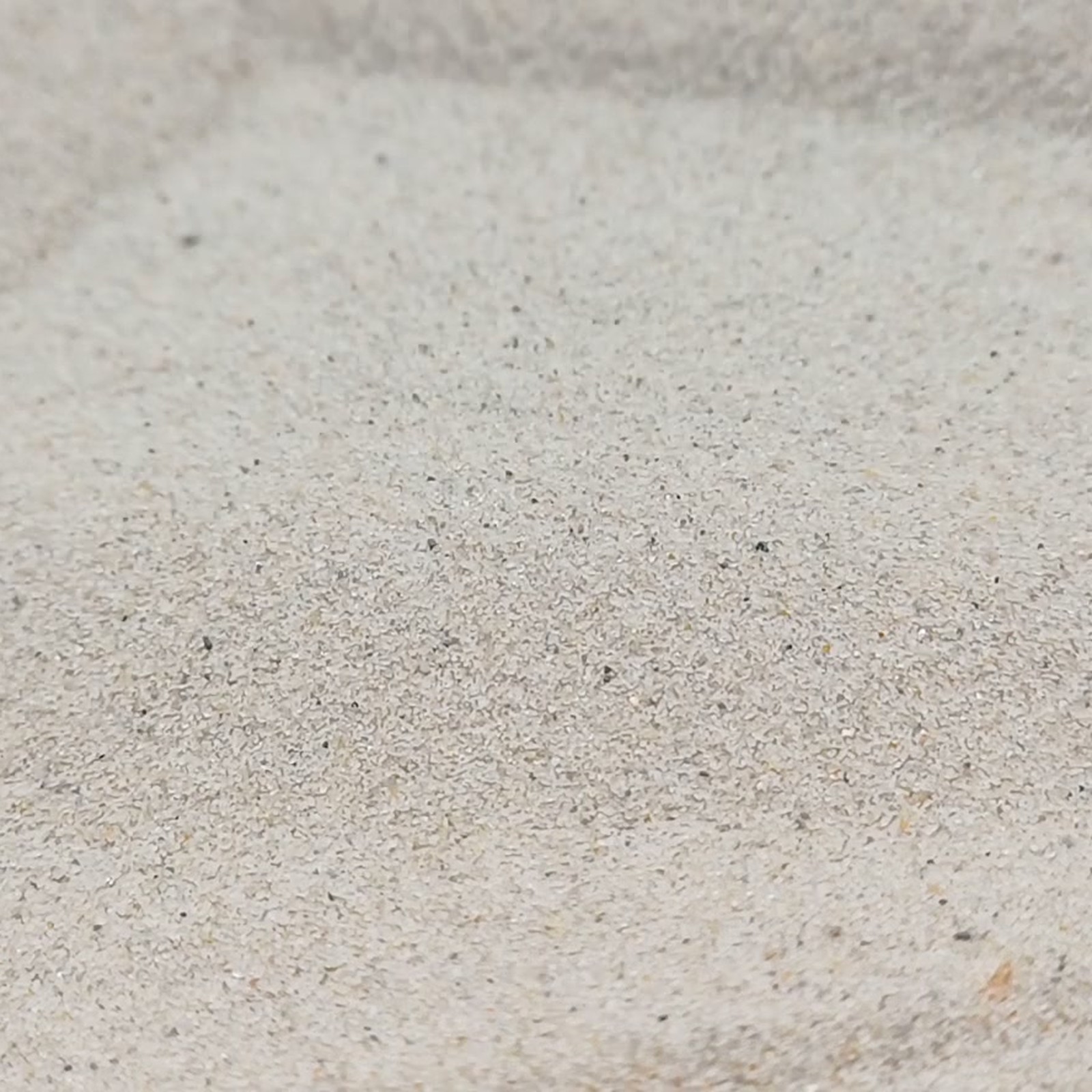 Chinchillasand Naturbeige, 0,1–0,3 mm, 25 kg: Feine Kornfläche mit breiter Vertiefung.
