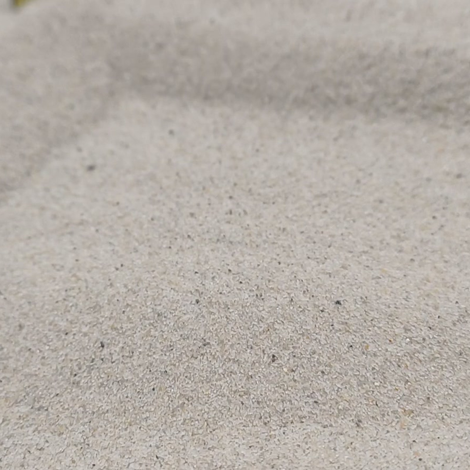 Chinchillasand Naturbeige, 0,1–0,3 mm, 25 kg: Flache Mulde zwischen beigen Sandrücken.