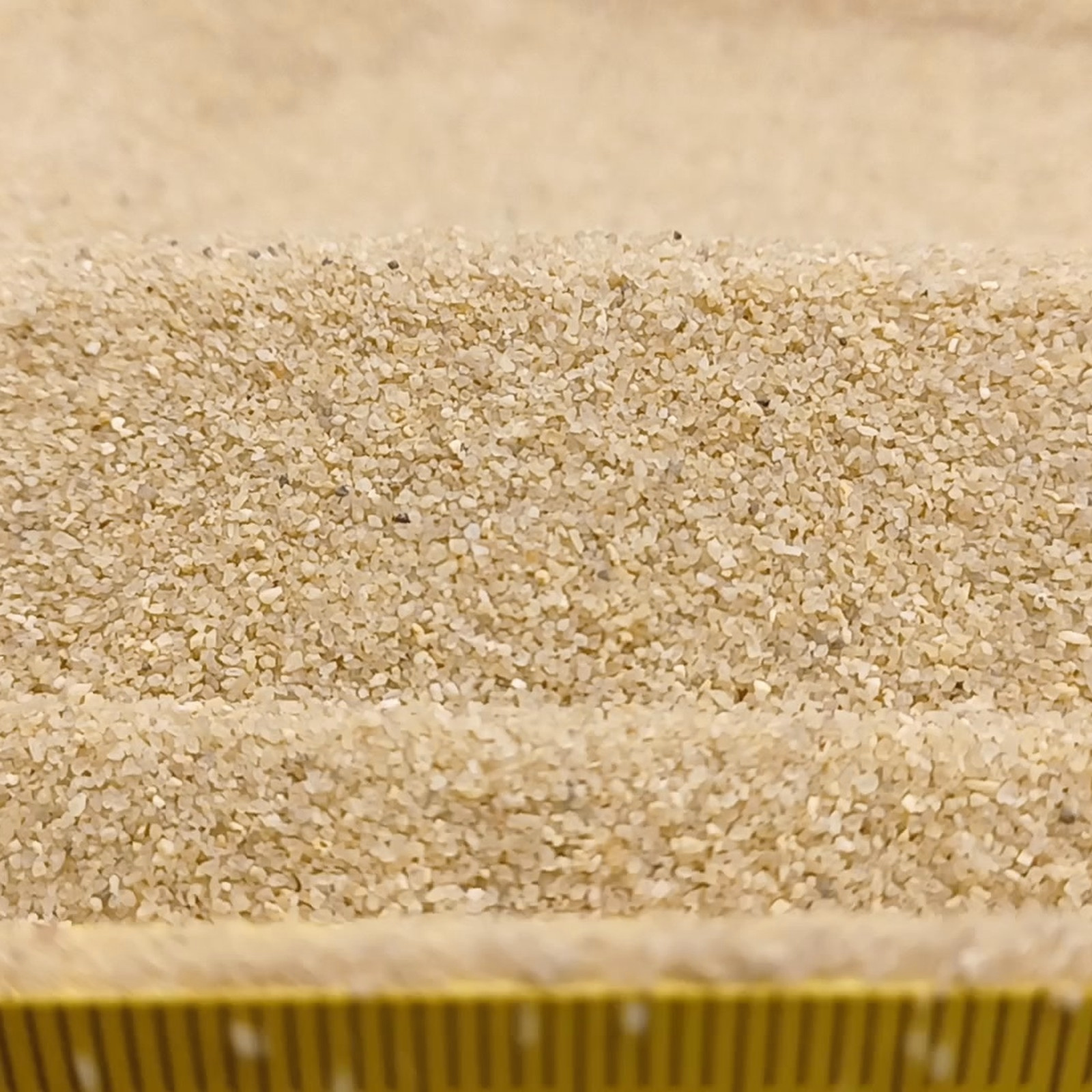 Aquariumsand Naturbeige, 0,1–0,6 mm, 25 kg: Erhöhter Sandrücken hinter einem Maßstab am Bildrand.