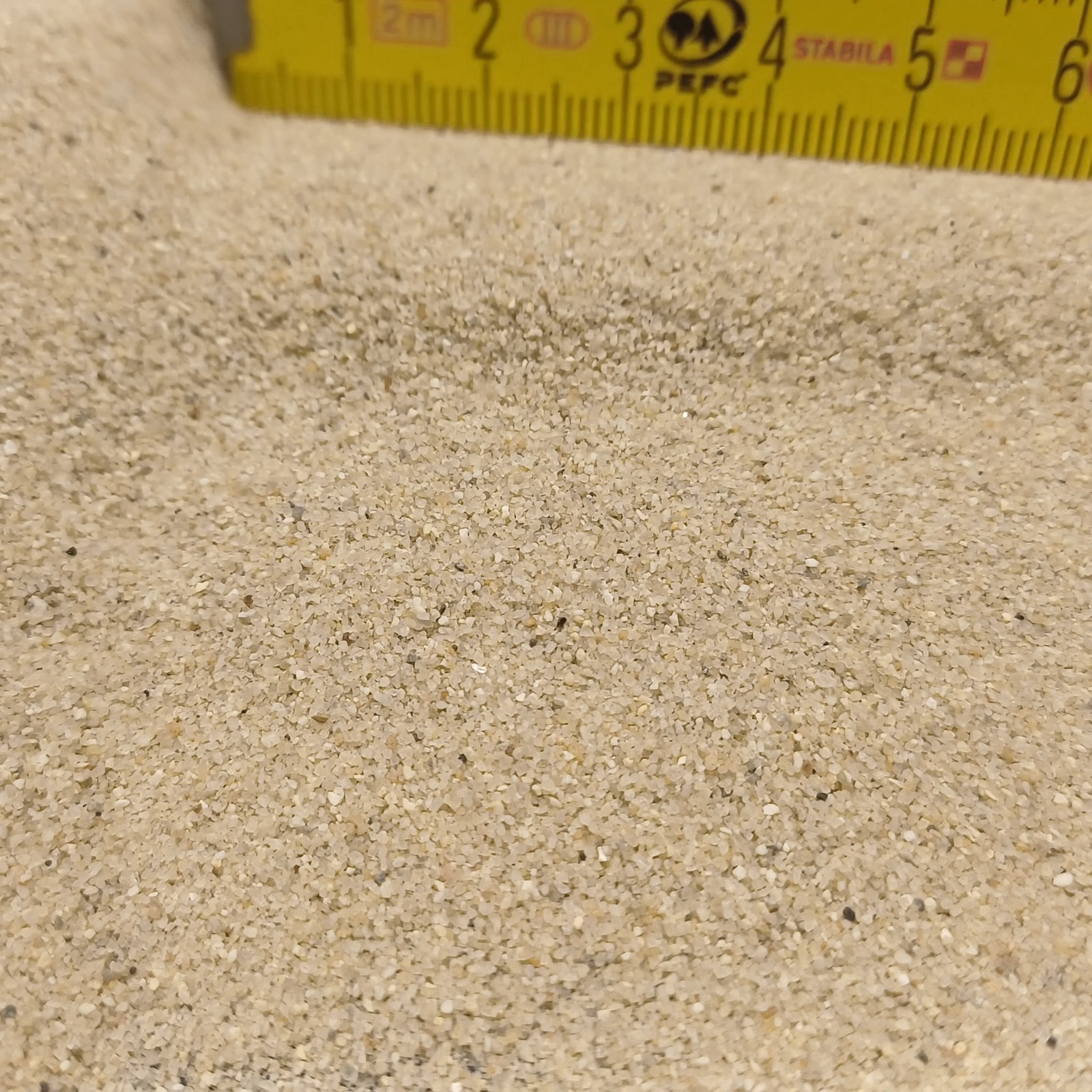Terrariumsand Naturbeige, 0,3–0,6 mm, 25 kg: Sandmulde vor einem Maßstab am oberen Rand.