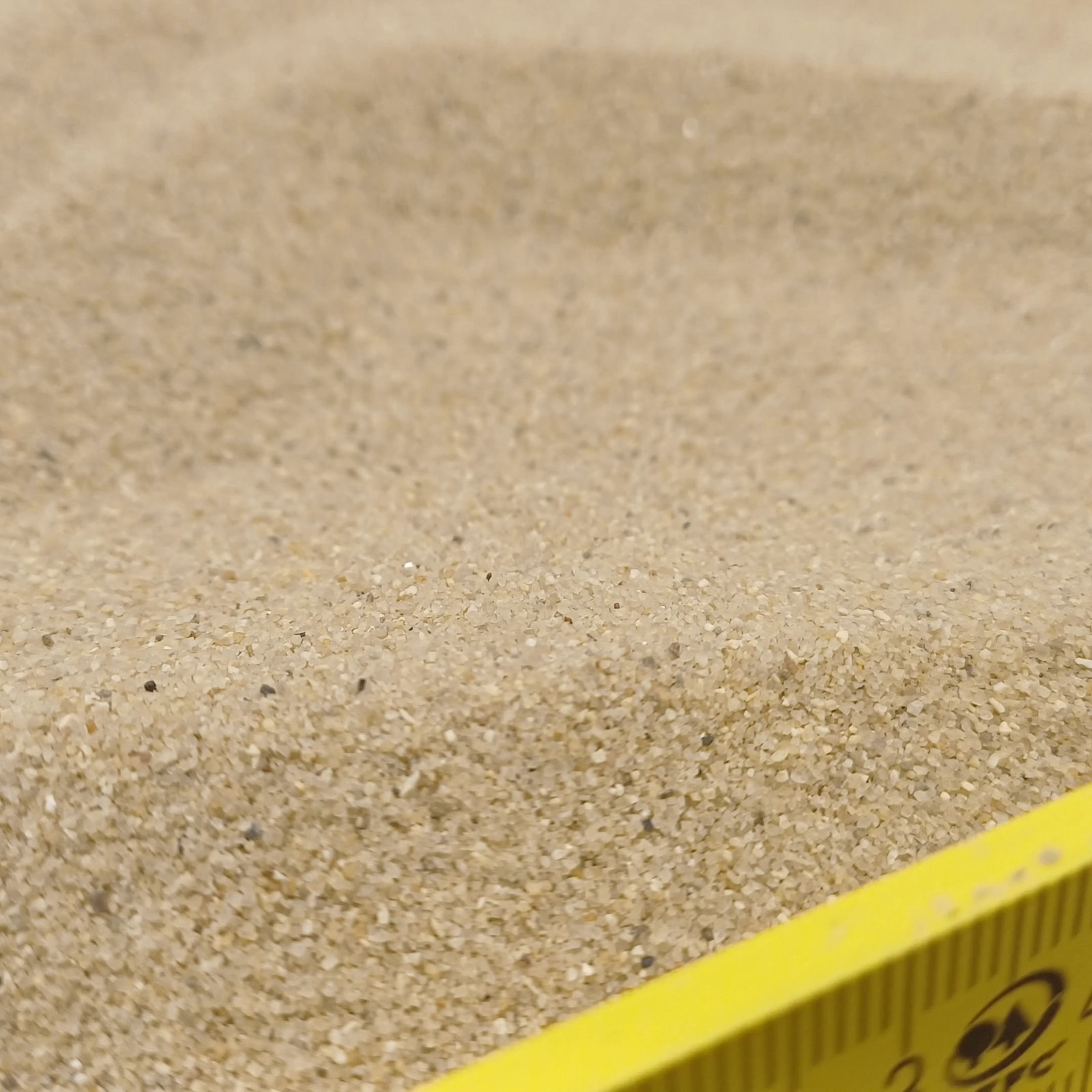 Terrariumsand Naturbeige, 0,3–0,6 mm, 25 kg: Zusätzliche Sandansicht hinter einem Maßstab am unteren Rand.