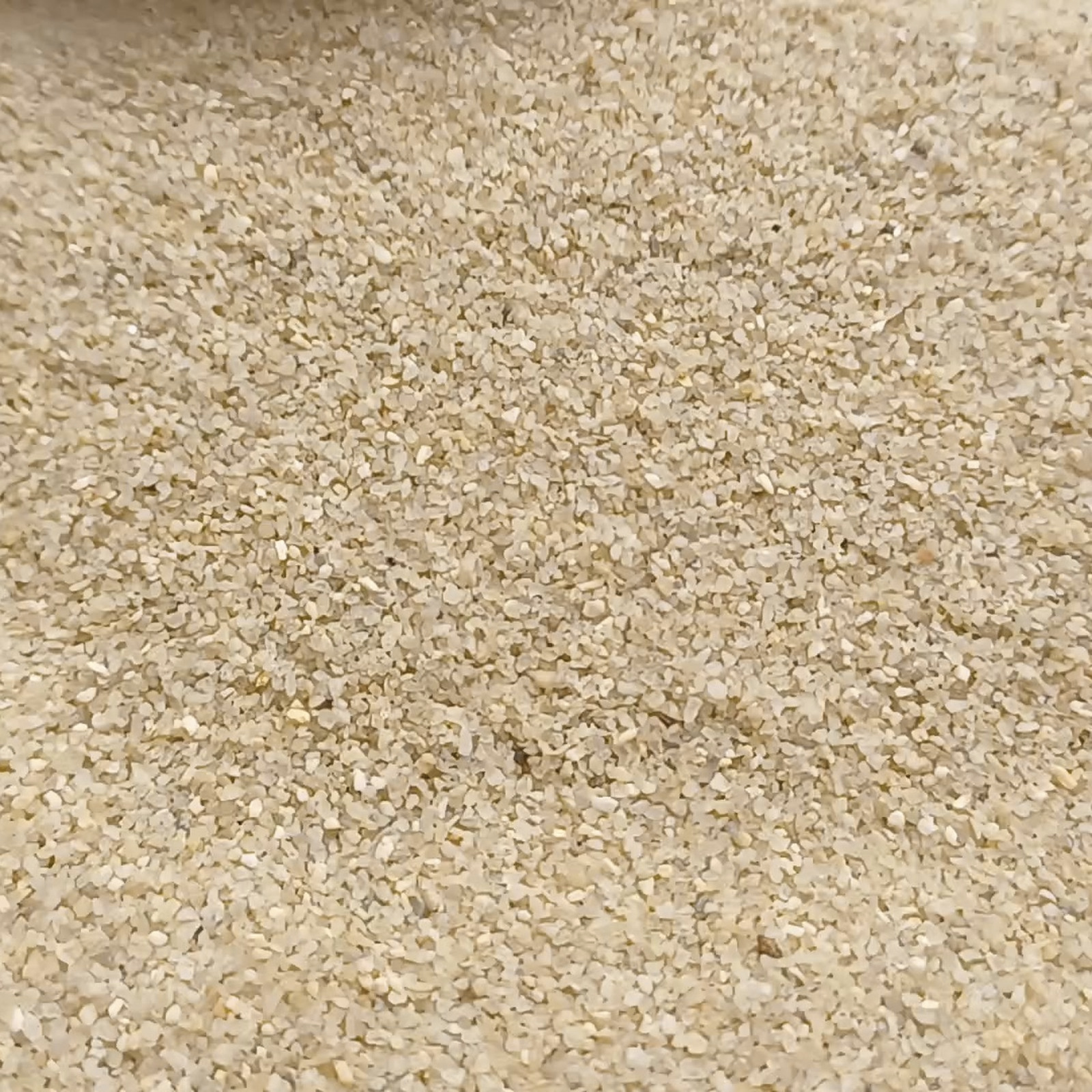 Vogelsand aus Quarzsand Naturbeige, Körnung 0,4–0,8 mm, 25 kg – Nahaufnahme der Kornstruktur.